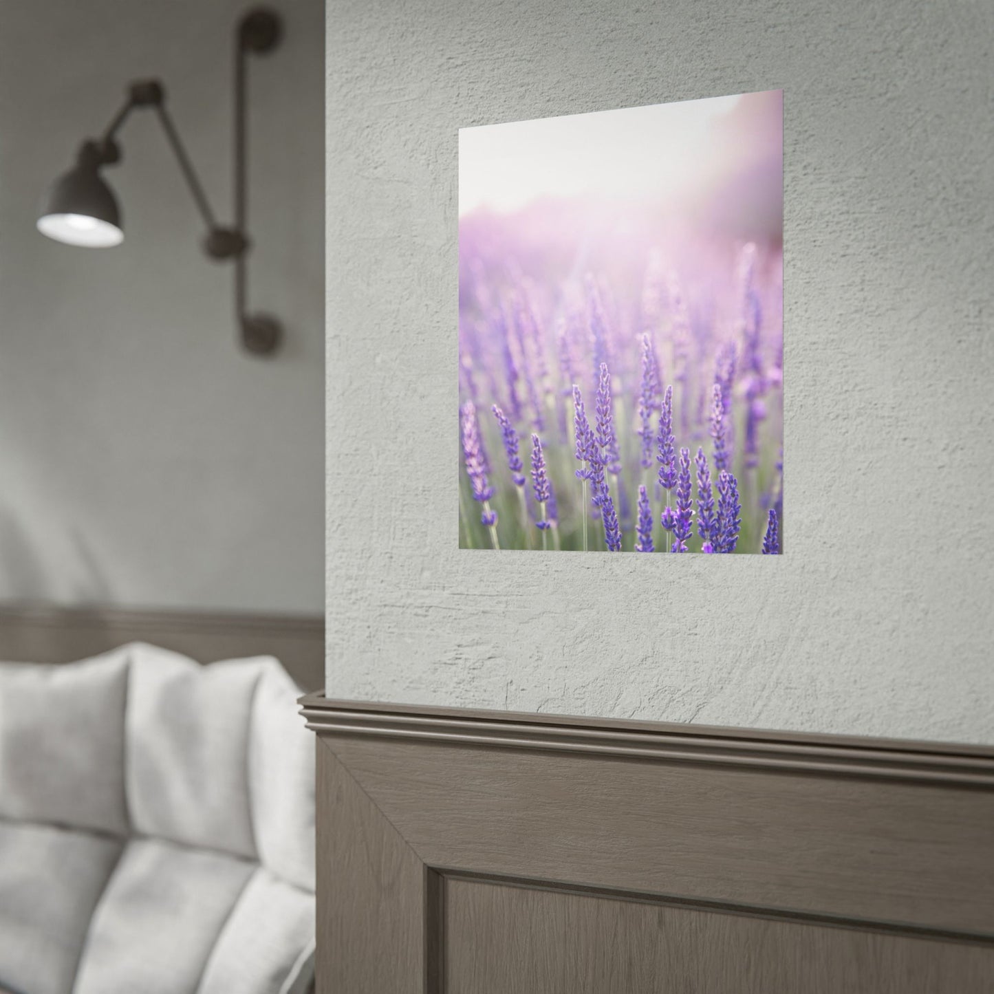 Framed lavender field poster mockup hanging on a bedroom wall above a upholstered headboard