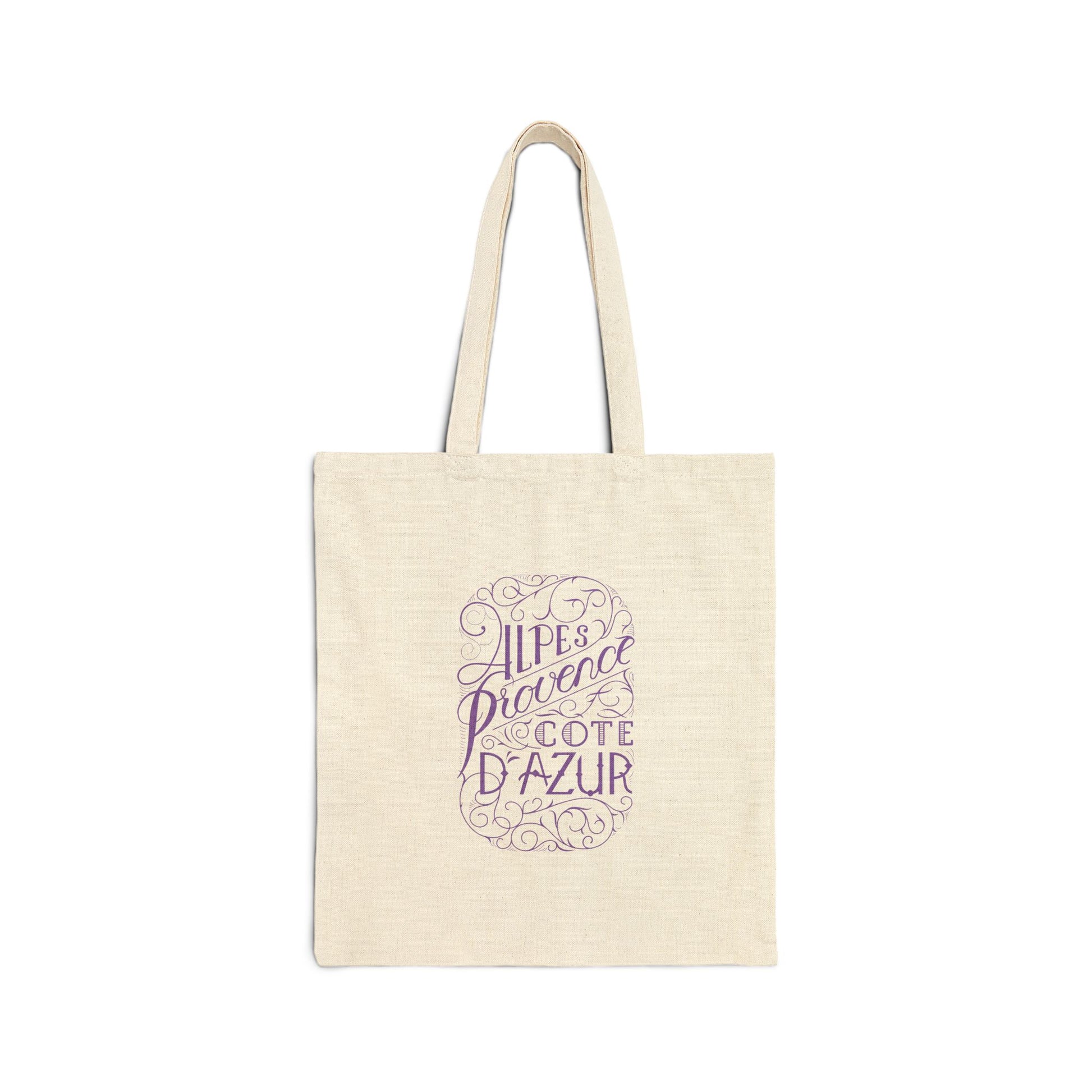 Flat front view of the natural canvas tote bag printed with ornate purple text reading Alpes Provence Cote d'Azur
