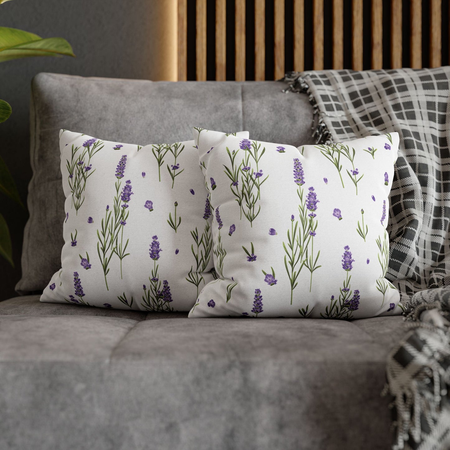 Two lavender sprigs throw pillows arranged together on a gray sofa with decorative throw blanket