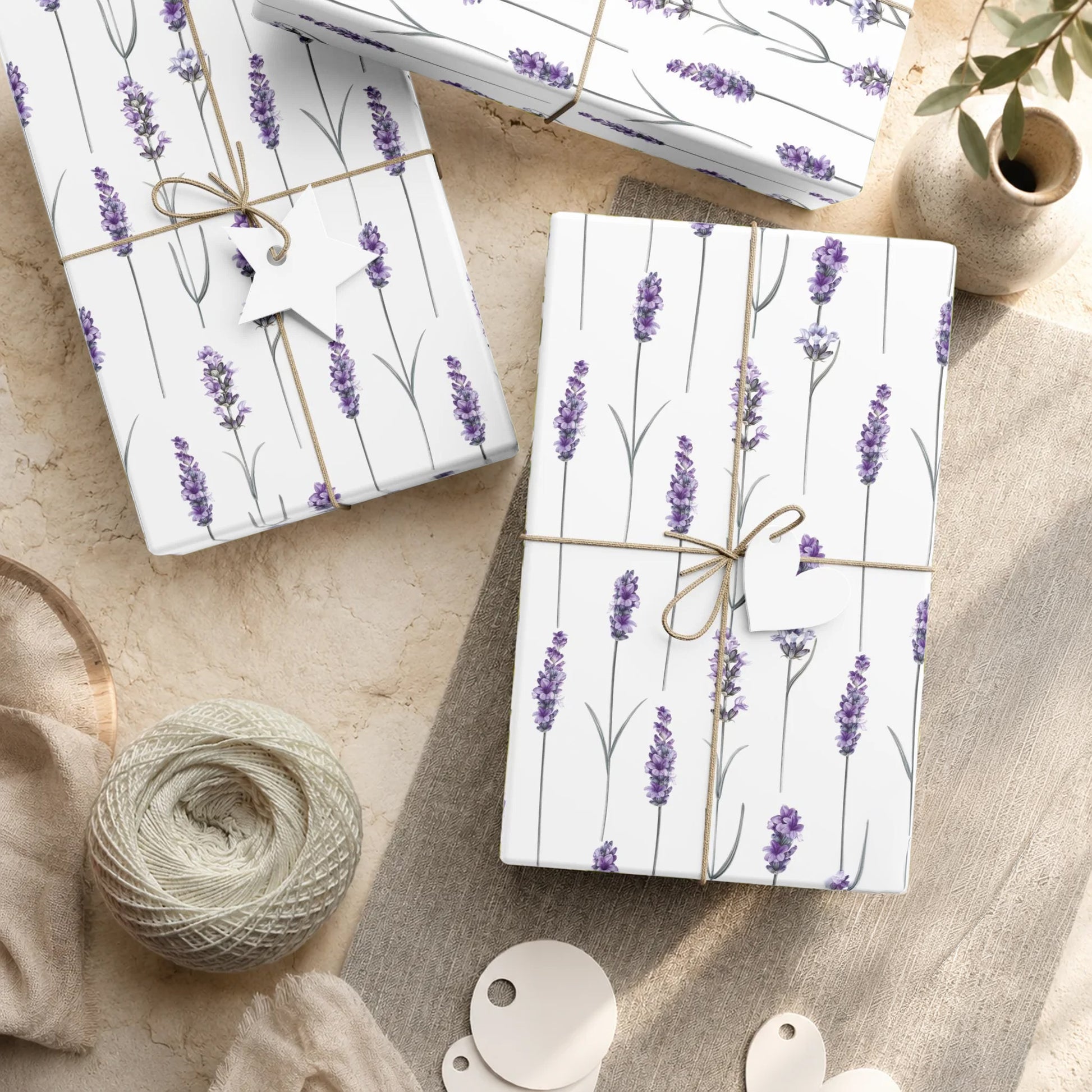 Wrapped gifts in lavender stem gift wrap paper tied with twine and paper tags