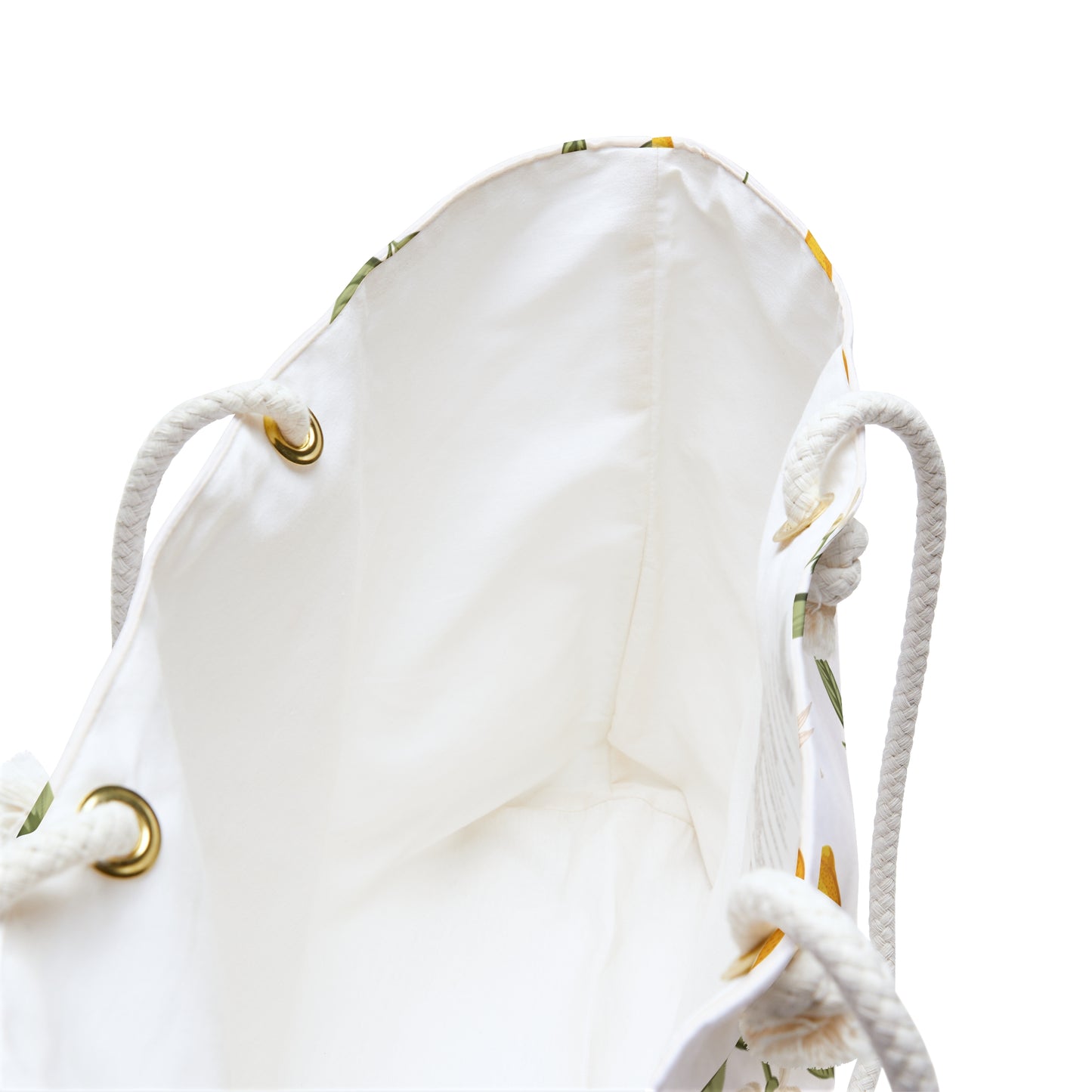 Close-up of the weekender bag's cream interior lining, rope handles, and brass-tone grommet accents