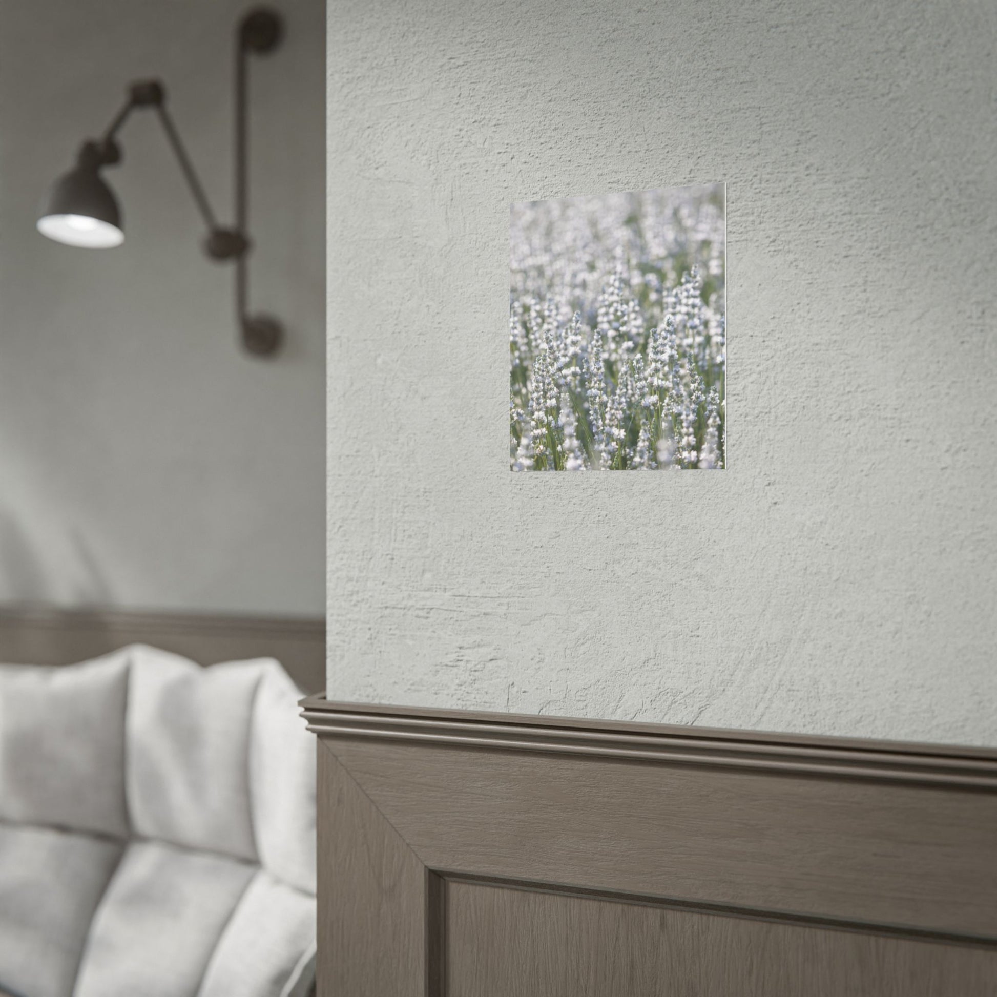 White lavender botanical print on a dark wall beside a sconce light in a minimal bedroom